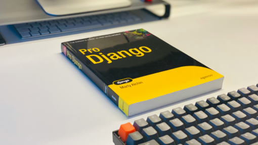 pro django by marty alchin sitting on a desk with a keyboard